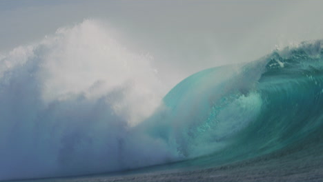 La-Cal-Agitada-Rocía-Niebla-En-El-Aire-Mientras-Una-Poderosa-Ola-Choca,-Cloudbreak-Fiji