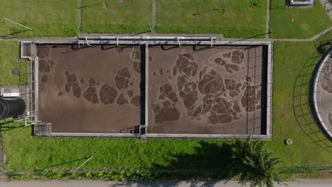 Luftaufnahme-Von-Oben-Nach-Unten-Einer-Kläranlage-Mit-Grünem-Gras