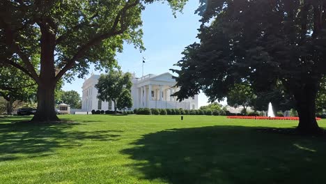 The-White-House-shot-in-4K-resolution-between-oak-trees-that-are-casting-shadows-to-the-lawn-that-was-just-mowed,-early-summer-midday,-Shot-in-4K-in-Washington-DC-during-the-early-summer-of-2024