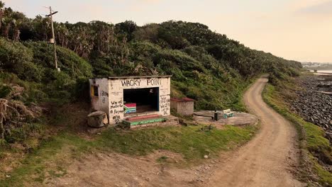 Abandoned-shelter-on-South-Africa's-coastline,-featuring-great-graffiti-and-rolling-waves---Slow-motion-footage