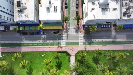 Aerial-top-down-shot-of-pedestrian-walking-on-crosswalk-at-Ocean-Drive