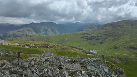 Mountain-walker-with-tripod-mounted-camera-on-crumbling-mountainside