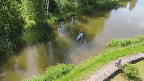 Fliegen-über-Junge-Frau-Stand-Up-Paddeln-Auf-SUP-Board-Auf-Teich-Im-Sommer