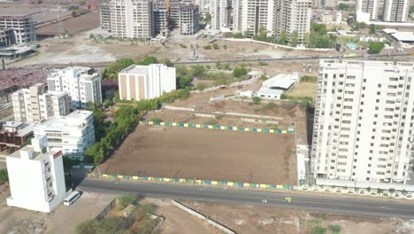 Vehículos-Circulando-Por-La-Carretera-Al-Fondo-Y-Casas-De-Vecindad-Y-Parcelas-Para-Fiestas-Visibles