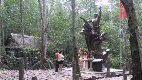 Dos-Personas-En-El-Monumento-A-Los-Caídos-En-La-Guerra-De-Vietnam-En-Un-Bosque-De-Manglares-En-La-Isla-De-Los-Monos,-Cerca-De-La-Ciudad-De-Ho-Chi-Minh.