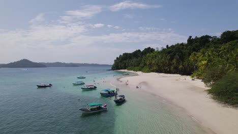 Tropical-beach-on-Coiba-Island-with-boats-and-lush-greenery-in-Panama