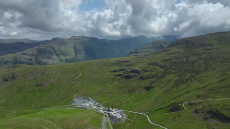 Slate-mine-at-top-of-mountain-pass-with-flight-towards-mountains-under-overcast-sky