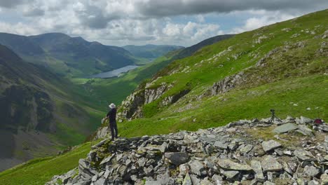 Solitary-mountain-walker-stood-on-crumbling-mountainside