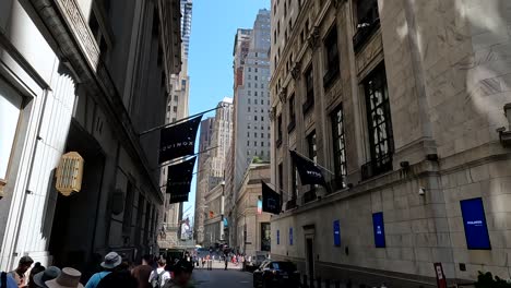 People-walk-past-and-film-New-York-Stock-Exchange-on-the-alley