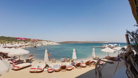 Club-De-Playa-Con-Bandera-Azul-En-Izmir-Cesme-Alacati,-Sombrillas-De-Playa,-Sillas,-Fiesta-En-La-Playa