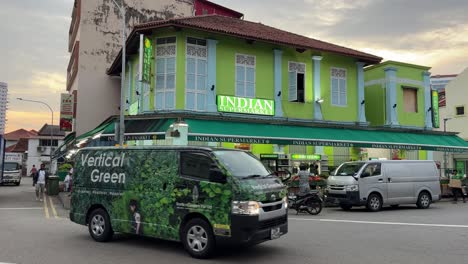 Ausländische-Arbeiter-überqueren-Die-Straße-Und-Vor-Dem-Hintergrund-Eines-Indischen-Supermarkts-In-Little-India,-Singapur