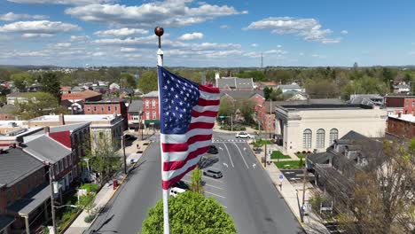 Patriotic-american-flag-on-city-square-of-small-town-during-sunny-day