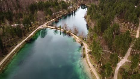 Sensational-aerial-shot-of-colorful-lake-of-Bluntauseen-in-Golling-surrounded-by-mountains,-Austria