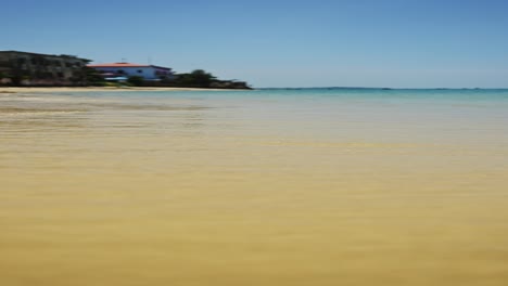 Wellen-Plätschern-Ans-Ufer-Eines-Sandstrands,-Vertikales-Video-Vom-Meer-In-Sansibar-Für-Soziale-Medien,-Instagram-Reels-Und-Tiktok-Mit-Wunderschönem-Sand,-Türkisfarbenem-Meerwasser,-Wellen-Plätschern-Ans-Ufer-Mit-Klarem-Blauen-Himmel