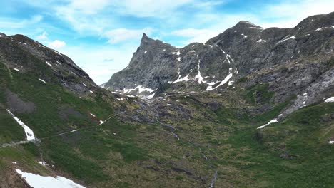 Eine-Atemberaubende-Luftaufnahme-Eines-üppig-Grünen-Tals,-Umgeben-Von-Schneebedeckten-Bergen