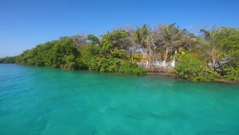 the-lush-Belize-Keys,-showcasing-vibrant-green-foliage-on-an-island-surrounded-by-crystal-clear-turquoise-waters