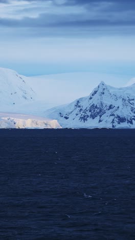 Antarctica-Winter-Coast-Landscape-of-Glacier-and-Mountains,-Beautiful-Dramatic-Antarctic-Peninsula-Coastal-Scenery-and-Snowcapped-Mountain,-Vertical-Video-for-Social-Media,-Instagram-Reels-and-Tiktok