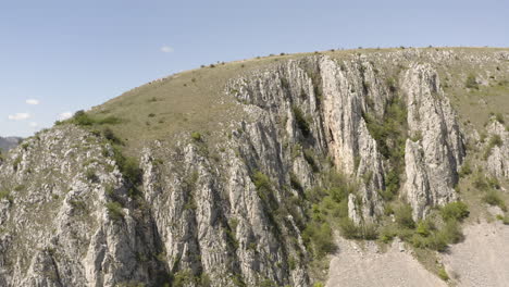 Aerial-wide-shot-showing-idyllic-mountains-of-Romania-during-sunny-day-with-blue-sky