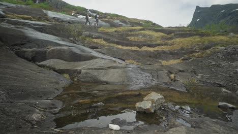 A-couple-hikes-the-rocky-terrain-of-Blavatnet-in-Hornindalsætra,-Norway,-enjoying-a-scenic-adventure