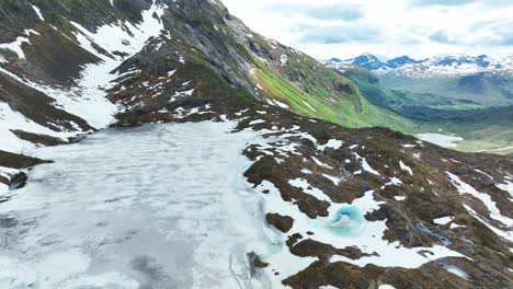 Frozen-mountain-lake-with-melting-snow-and-scenic-landscape-in-Norway-during-spring