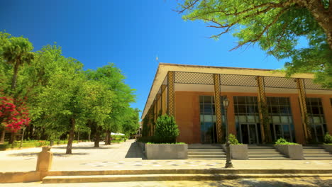 Ein-Modernes-Gebäude-Mit-Großen-Fenstern-Und-Einer-Dekorativen-Fassade,-Umgeben-Von-üppigem-Grün-Unter-Einem-Klaren-Blauen-Himmel---In-Ronda,-Span