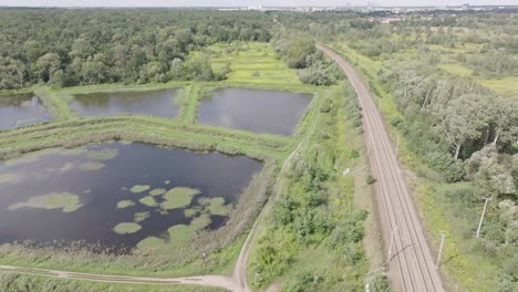 Drone-shot-of-railroad-near-a-ponds