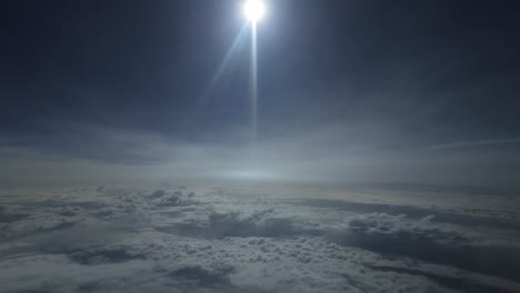 POV-dramatic-view-flying-over-the-clouds-with-a-blinding-sun-ahead-at-supersonic-speed-as-seen-by-the-pilot-of-a-jet-with-the-halo-of-the-sun