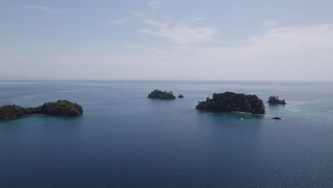 Lush-tropical-islands-in-clear-blue-ocean-on-a-sunny-day,-aerial-view