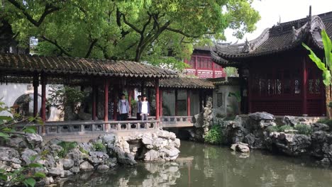 Tourists,-water-pond-in-Yuyuan-Garden-in-Shanghai,-China,-panning-shot-with-slow-motion