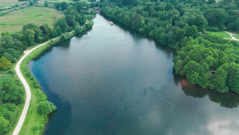 Carretera-Junto-Al-Lago-Con-Densa-Vegetación-En-El-Lago-Trentham-En-Inglaterra