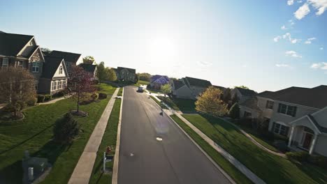 FPV-drone-flight-on-a-street-of-a-middle-class-neighborhood-on-a-sunny-day-with-a-blue-sky-in-America,-Pennsylvania,-Lancaster