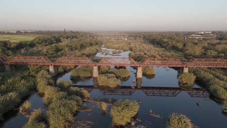 Old-railroad-bridge-over-the-seasonal-Komati-River-in-South-Africa,-early-morning-golden-light