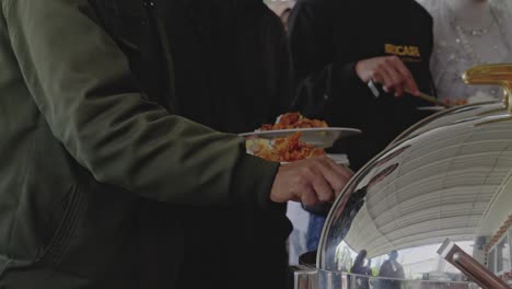 Group-Of-People-Eating-Catering-Buffet-Food-At-Traditional-Wedding