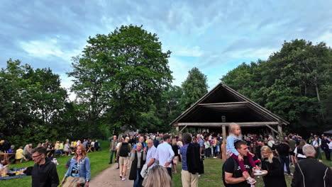 Slow-motion-view-of-large-crowd-of-people-gathering-outdoors-at-Midsummer's-Eve-friends-family-social-event-celebrations-Open-Air-Museum-Estonia-Tallinn-Europe