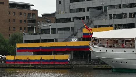 Walking-past-the-Colombian-flags-near-Juan-Sebastián-de-Elcano,-Canary-Wharf,-London,-United-Kingdom