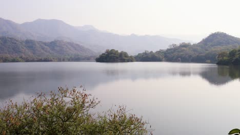 Neblige-Berglandschaft-Mit-Unberührtem-See-Am-Tag-Aus-Flachem-Winkel