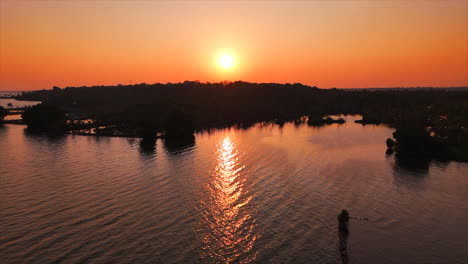 Backwater-sunset,-Backwaters-at-palms-and-big-orange-sun-background