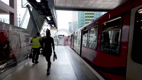 Canary-Wharf,-London:-The-end-of-the-metro-platform-in-Canary-Wharf,-showcasing-the-sleek,-modern-design-and-bustling-commuter-activity