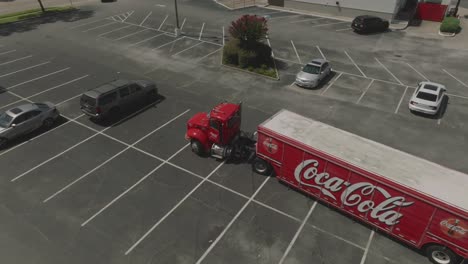 An-aerial-drone-view-of-a-Coca-Cola-delivery-truck-pausing-in-a-parking-lot-between-deliveries-in-Clear-Lake,-Houston,-Texas