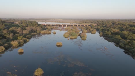 Old-bridge-with-trucks-queuing-over-the-seasonal-Komati-River-in-South-Africa,-early-morning-aerial-shot