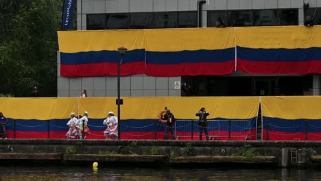 Gente-Bailando-Mientras-Espera-El-Arco-Gloria-En-Canary-Wharf,-Londres,-Reino-Unido