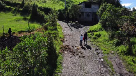 Vuelo-Aéreo-Con-Drones-Sobre-Una-Mujer-Y-Un-Niño-En-La-Calle-Del-Cantón-Mejía,-Ecuador,-Tiro-Con-Plataforma-Rodante-En-Un-Día-Soleado