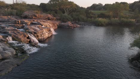 Drohnenaufnahme-Eines-Felsigen-Abschnitts-Im-Fluss-Komati,-Dessen-Wasser-In-Einen-Großen-Pool-Strömt