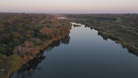 Forward-descending-aerial-drone-shot-of-the-Komati-River-and-bushveld-in-South-Africa,-early-morning