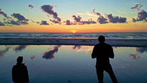 Drohne-Zeigt-Reisepaar-Sightseeing-Sonnenuntergang-Lettland-Breiten-Blauen-Strand-Küste