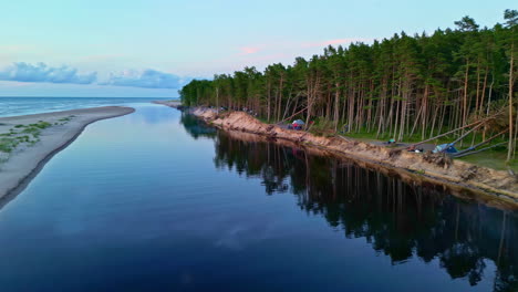 Drone-fly-Latvian-woods-sunset-skyline,-water-reflection-landscape,-Baltic-Sea