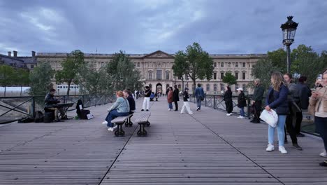 People-at-Pont-des-Arts-with-Institut-de-France-on-background-in-Paris,-France