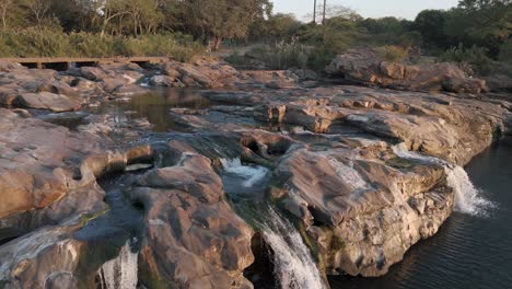 Sección-Rocosa-En-El-Río-Komati-Con-Agua-Fluyendo-Hacia-Una-Gran-Piscina,-Perspectiva-Aérea