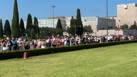 Panning-shot-of-a-huge-crowd-and-a-long-queue-of-tourists-waiting-to-enter-the-Mosteiro-dos-Jerónimos-in-Belem,-Lisbon,-Portugal