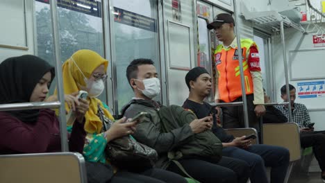 Passengers-wearing-masks-ride-a-train-in-Sudimara-Station,-South-Tangerang